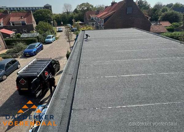 Nieuw bitumen plat dak met uitzicht over woonwijk in Voerendaal