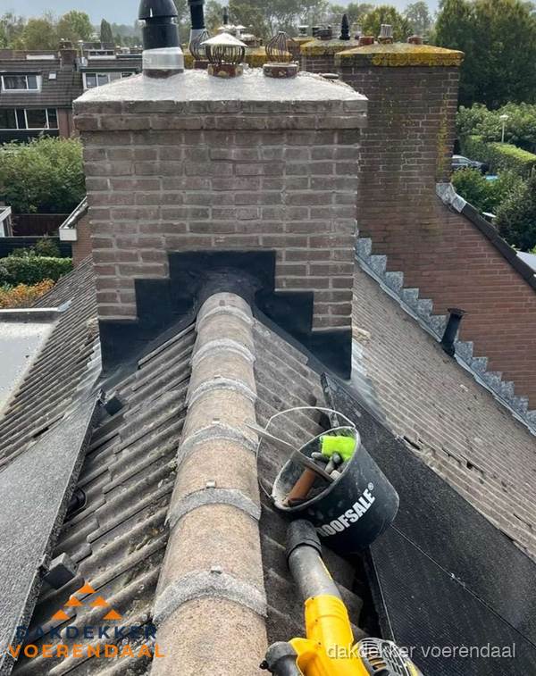 Schoorsteen met loodaansluiting en nokvorst op pannendak in Voerendaal