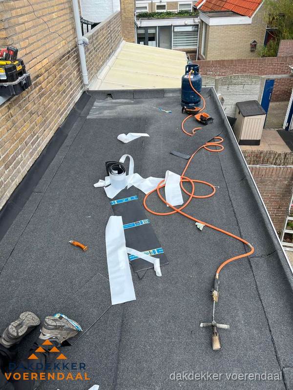 Dakdekkers bezig met bitumen dakbedekking in Voerendaal