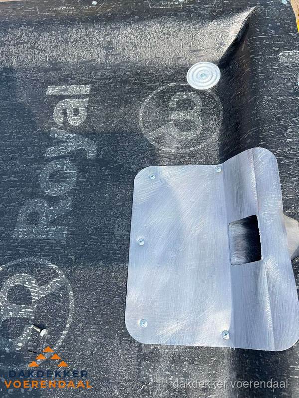 Dakdoorvoer met metalen afvoerplaat op bitumen dak in Voerendaal