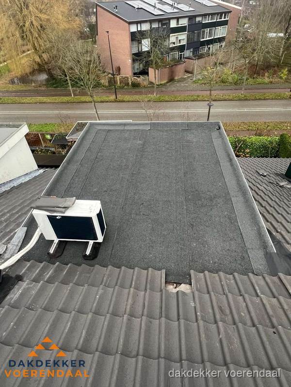 Plat dak inspectie met bitumen bedekking naast schuin pannendak in Voerendaal Plat dak inspectie met bitumen bedekking naast schuin pannendak in Voerendaal