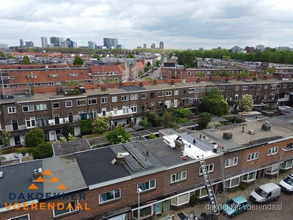 Spoed dakdekker aan het werk op plat dak in woonwijk Voerendaal