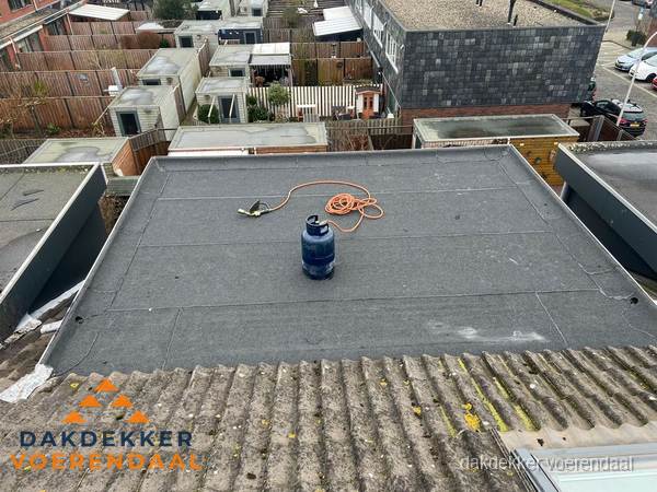 Plat dak met bitumen dakbedekking en brander in Voerendaal