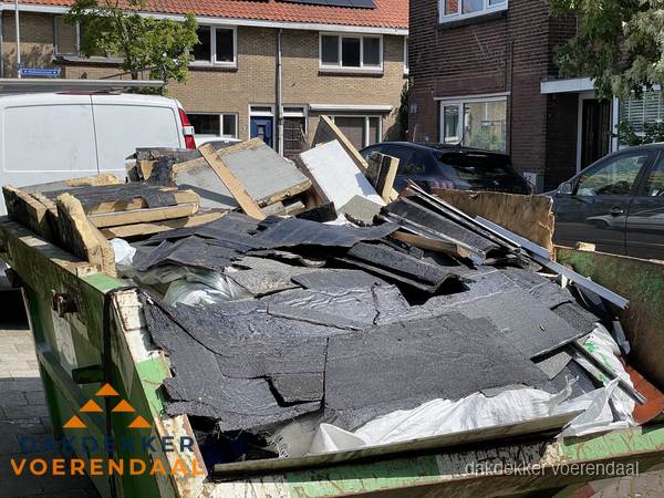 Afvalcontainer met gesloopt dakmateriaal tijdens dakkapel renovatie in Voerendaal Afvalcontainer met gesloopt dakmateriaal tijdens dakkapel renovatie in Voerendaal