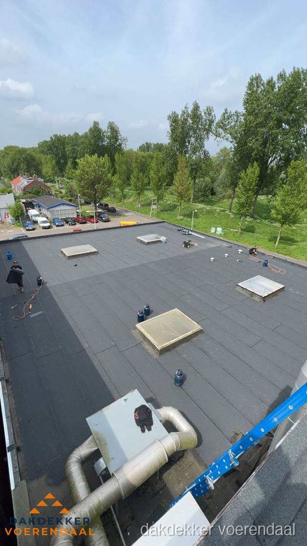 Dakdekker aan het werk op groot plat dak met bitumen in Voerendaal Dakdekker aan het werk op groot plat dak met bitumen in Voerendaal