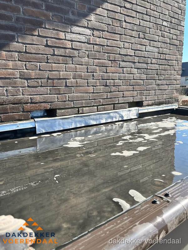 Stilstaand water op plat dak door slechte afwatering in Voerendaal Stilstaand water op plat dak door slechte afwatering in Voerendaal